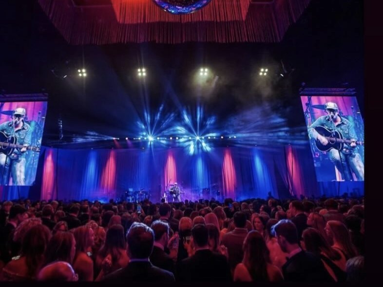 A corporate gala audience watching Sugar Shaker on stage with live IMAG video walls