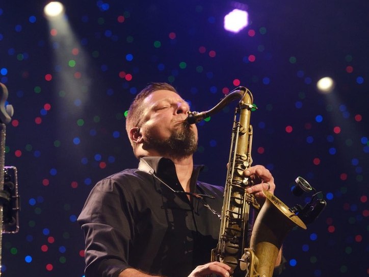 Sugar Shaker's saxophonist taking a solo under stage lights