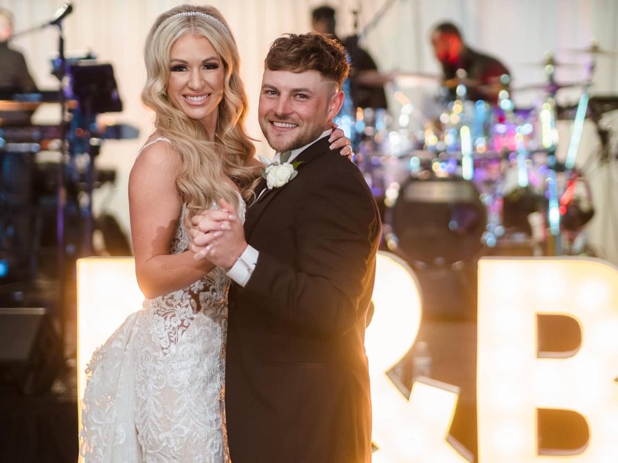 A couple's first dance in front of the Sugar Shaker band at their wedding reception