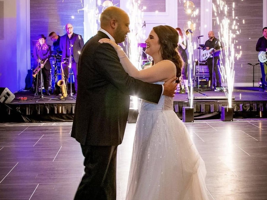 First dance framed by sparkler fountains with Sugar Shaker performing on stage behind