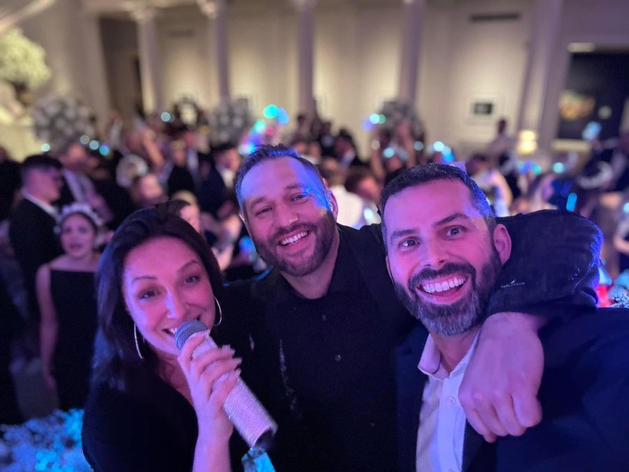 A Sugar Shaker vocalist singing with wedding guests on the dance floor